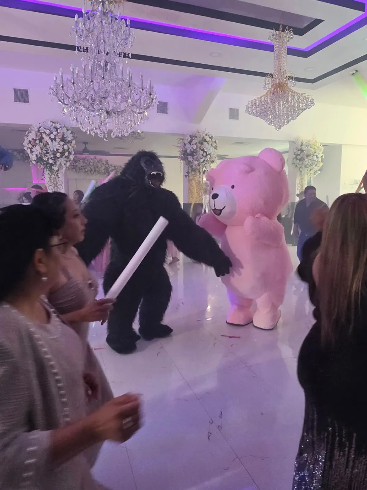 Mascotas de gorila y osito rosa bailando con invitados